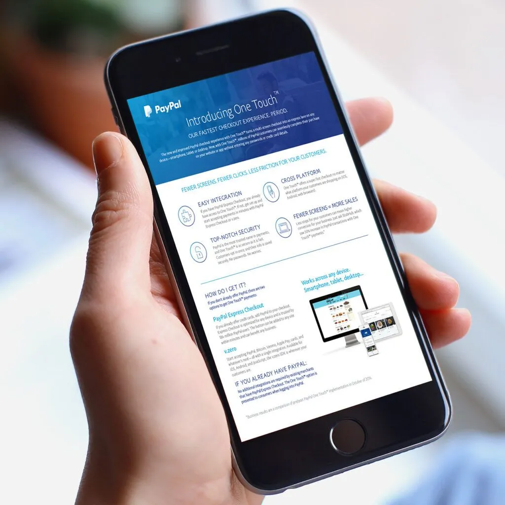 A hand holds an iPhone displaying a PayPal promotional page for "One Touch," highlighting features like easy integration, top-notch security, and higher sales. The page provides steps on getting started with the service.