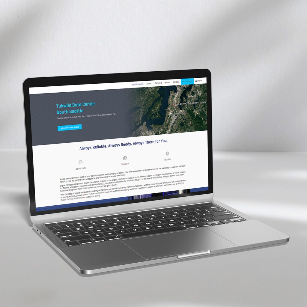 A laptop on a white surface displaying a website about the Tukwila Data Center, South Seattle. The screen shows a map and text emphasizing reliability and readiness.