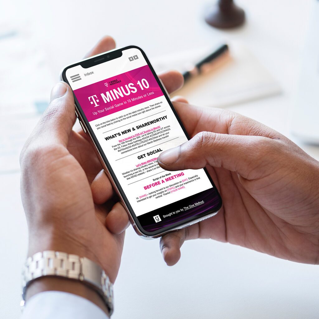 A person holds a smartphone displaying a website with a pink header titled "MINUS 10." The text is focused on news and suggestions for social media preparation. The background shows a white surface with blurred objects.