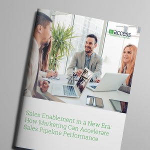 A group of four people are sitting around a table with laptops and documents, deeply engaged in a meeting focused on sales enablement. The cover of a brochure titled "Sales Enablement in a New Era: How Marketing Can Accelerate Sales Pipeline Performance" is prominently displayed.
