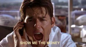 A person talking on a phone with a serious expression, mouth open as if shouting. The text "SHOW ME THE MONEY" is displayed at the bottom of the image.