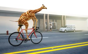 A giraffe riding a red bicycle on a city street, passing by a white van and modern buildings. The giraffe's long neck towers above the scene, creating a whimsical and surreal impression.