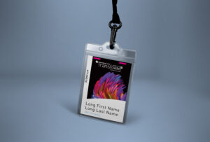An attendee badge with a lanyard. The badge has colorful abstract artwork at the top and text below, showing "Transform" in bold, with a placeholder for name and company: "Long First Name, Long Last Name, ABC Company.