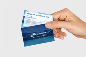 A hand holding two business cards. The top card is a Network Insurance Card with placeholder details, featuring a mountain and lake design. The bottom card is for MTA Wholesale, displaying a similar nature-themed background.