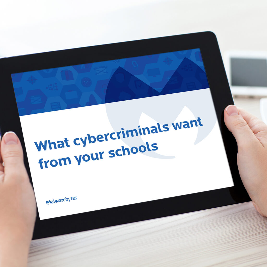 A person holds a tablet displaying a presentation slide titled "What cybercriminals want from your schools," with a blue and white design. The image emphasizes the topic of cybersecurity in educational institutions.