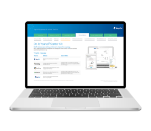 A laptop displaying the PayPal Business in a Box Toolkit webpage. The screen highlights a "Do-It-Yourself Starter Kit" with icons and text about business tools and services. The PayPal logo is visible in the top right corner.
