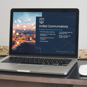 A laptop on a table displays a presentation slide titled "Unified Communications." The slide shows a cityscape and text about services like 24/7 monitoring, user provisioning, account management, and monthly reporting.