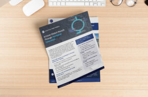 A flyer titled "Achieve Global Reach through Portland Colocation" rests on a wooden desk with a keyboard, mouse, and glasses. The flyer features a circular flowchart and text detailing information on global connectivity solutions.