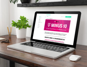 A laptop on a wooden desk displaying an email or newsletter titled "T Minus 10" with a pink background. The screen features text about social media tips. A small potted plant and wireless mouse sit beside the laptop.